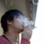 ベランダでタバコを吸う男性
