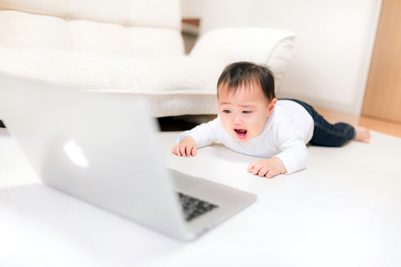 パソコンを見て泣く赤ちゃん