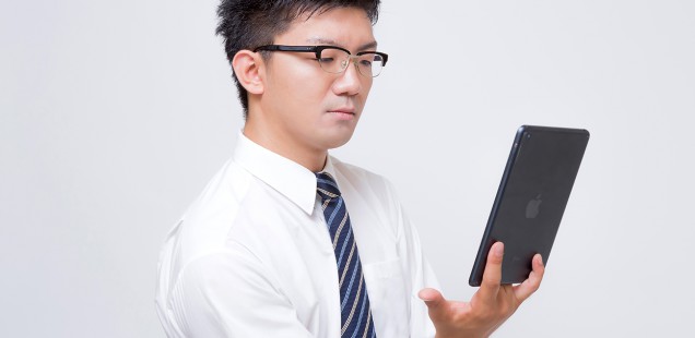 iPad mini で電子書籍を読むビジネスマン
